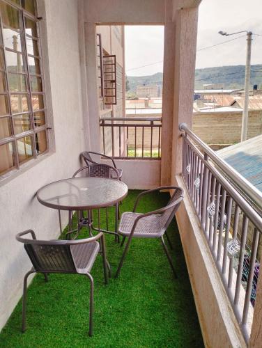 a balcony with three chairs and a table on a balcony at JNJ luxury homes in Naivasha