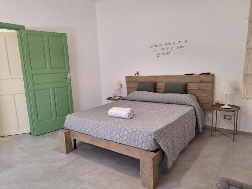 a bedroom with a bed and a green door at Pura Vida Barocca in Ragusa