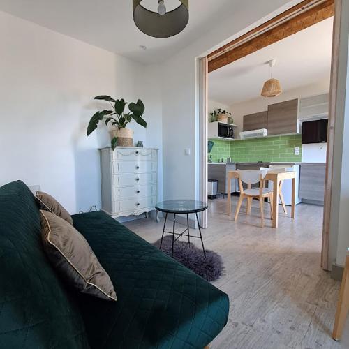 un salon avec un canapé vert et une table dans l'établissement Chez Christine Et Fabrice, à Font-Romeu-Odeillo-Via