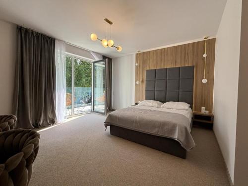 a bedroom with a large bed and a large window at Resort Eden Premium Domki Jacuzzi, sauna in Jastrzębia Góra