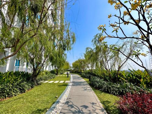 a walking path in a park with trees and flowers at Benson Tower Surabaya Apartment 2BR by Le Ciel Hospitality in Lontar