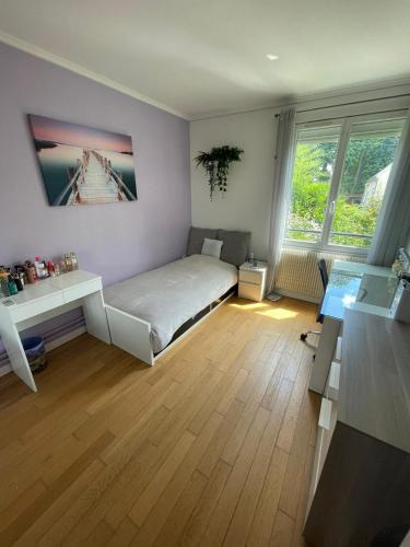 ein Schlafzimmer mit Bett, Schreibtisch und zwei Fenstern in der Unterkunft Colibri in Rocquencourt