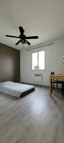 Cette chambre comprend un lit et un ventilateur de plafond. dans l'établissement Villa 6 couchages piscine, à Les Taillades