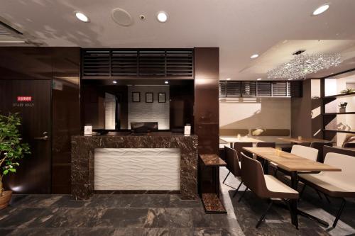 a restaurant with a bar and tables and chairs at Tanimachi LUXE HOTEL in Osaka