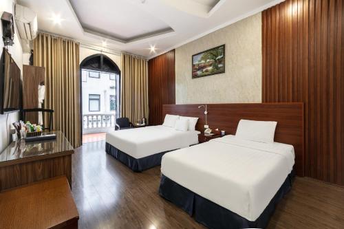 a hotel room with two beds and a window at A25 Hotel - 12 Liên Trì in Hanoi