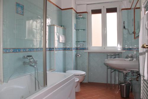 a bathroom with a tub and a toilet and a sink at Monnalisa Home in Rome