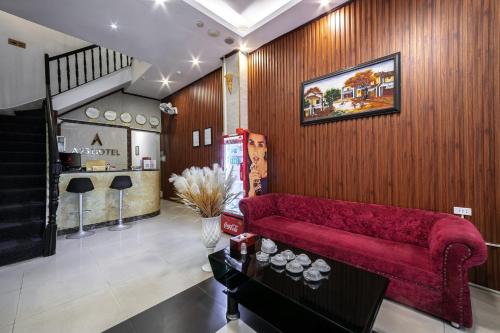 a living room with a red couch and a staircase at A25 Hotel - 12 Liên Trì in Hanoi
