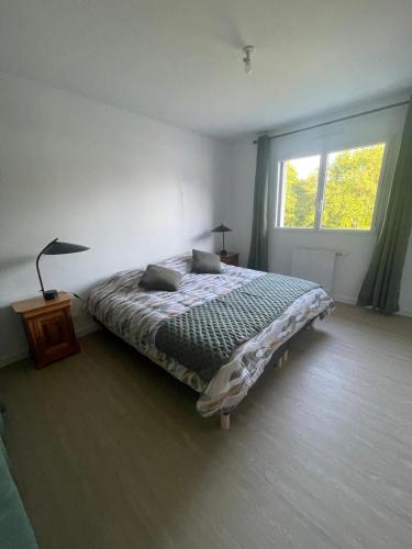 une chambre avec un lit et une fenêtre dans l'établissement Maison du soleil levant, à Plescop