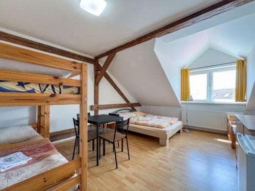 a bedroom with bunk beds and a table and a bed at Penzion U Fandy in Šatov