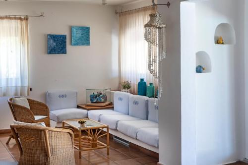 a living room with a white couch and chairs at Hotel Corallaro in Santa Teresa Gallura