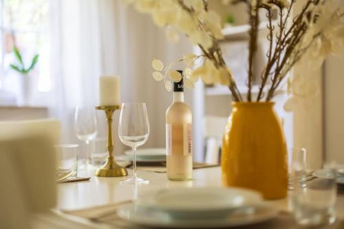 a table with a bottle of wine and glasses on it at Ferienhaus Goldene Zeit I Terasse I Parkplatz I 3 SZ I 2 Bäder I 2 min zum See in Joachimsthal