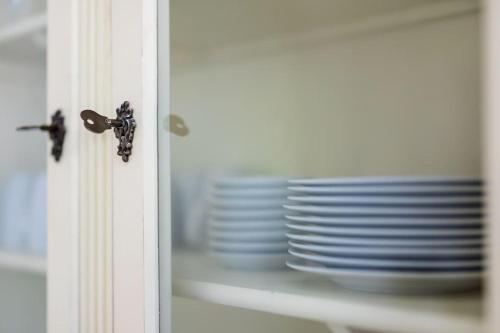 a stack of plates sitting on a shelf next to a door at Ferienhaus Goldene Zeit I Terasse I Parkplatz I 3 SZ I 2 Bäder I 2 min zum See in Joachimsthal