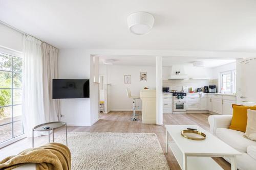a living room with a white couch and a table at Ferienhaus Goldene Zeit I Terasse I Parkplatz I 3 SZ I 2 Bäder I 2 min zum See in Joachimsthal