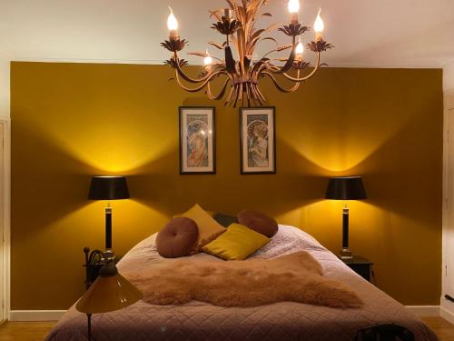 a bedroom with a large bed with a chandelier at Queen Suite Centre Alkmaar in Alkmaar