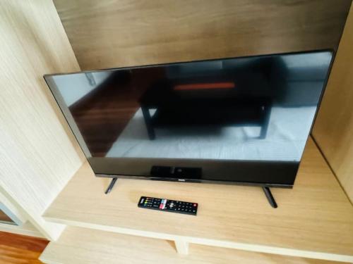 a flat screen tv sitting on a stand with a remote control at Muskiz Retreat, playa 5 mins, WIFI gratis in Muskiz