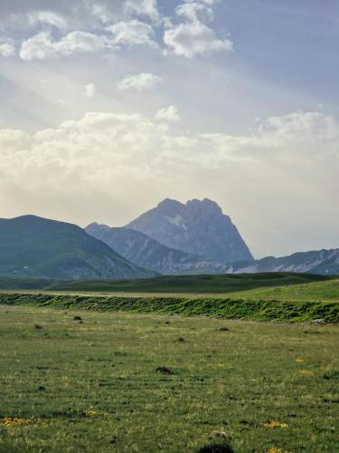 a field with a mountain in the background at TraMonti Apartments in Poggio Picenze