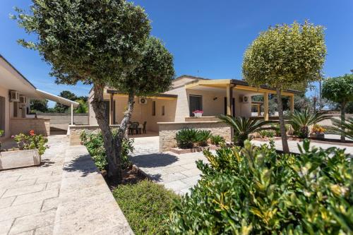 a house with a garden with trees and bushes at La Pineta Residence in Otranto