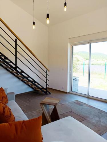 un salon avec un canapé et un escalier en colimaçon dans l'établissement Le Cocon d'Adrien, à Malijai