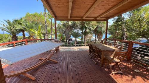 a wooden deck with a hammock and a table and chairs at Villaggio Dei Fiori in Sanremo