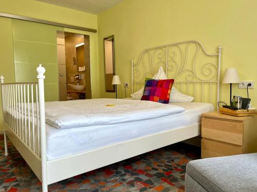 a bedroom with a white bed with a red pillow at Berghotel Talblick in Holzhau