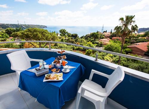 プラーイア・ア・マーレにあるHotel Blu Edenの海が見えるバルコニーに置かれた青いテーブルと椅子
