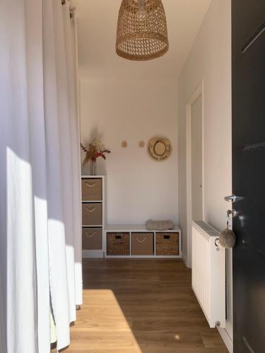 un couloir avec une pièce avec une commode et une lampe dans l'établissement Golfe du Morbihan, à Sulniac