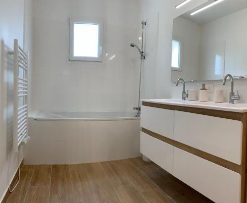 La salle de bains blanche est pourvue d'une baignoire, d'un lavabo et d'une baignoire. dans l'établissement Golfe du Morbihan, à Sulniac