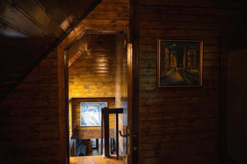 an open door of a wooden house with a picture at Pensiunea Lac in Arefu