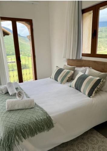 a large white bed in a room with a window at El Torreón de Muro in Boltaña