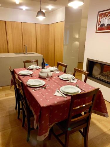 a dining room table with a red tablecloth on it at Casa Clarignano - SPA privata con bagno di vapore in Montefalco