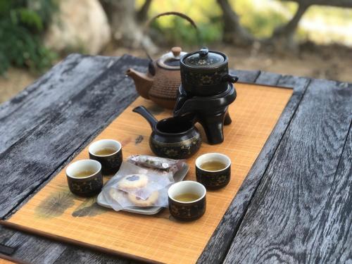 a table with a tea pot and cups of coffee at Ohana Village in Phương Phi
