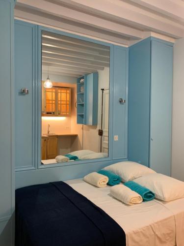 - une chambre avec un grand miroir au-dessus d'un lit dans l'établissement PARIS 4 Le Marais Place des Vosges, à Paris
