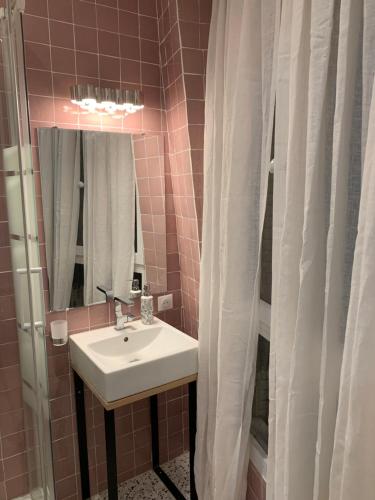 une salle de bain avec un lavabo et un miroir dans l'établissement PARIS 4 Le Marais Place des Vosges, à Paris