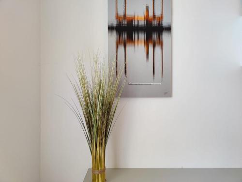 un vase avec de l'herbe assise sur une table dans l'établissement Les Saints Pères près du Vieux Port, à La Rochelle