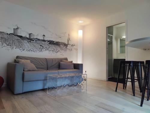 un salon avec un canapé et un tableau au mur dans l'établissement Les Saints Pères près du Vieux Port, à La Rochelle