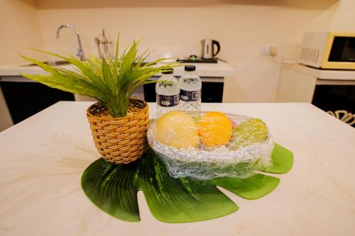 a basket of oranges on a counter with a plant at Royal Residence Dhaka in Dhaka