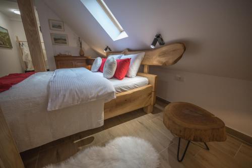 a bedroom with a bed with red pillows and a stool at Konak Lecic in TrÅ¡iÄ‡