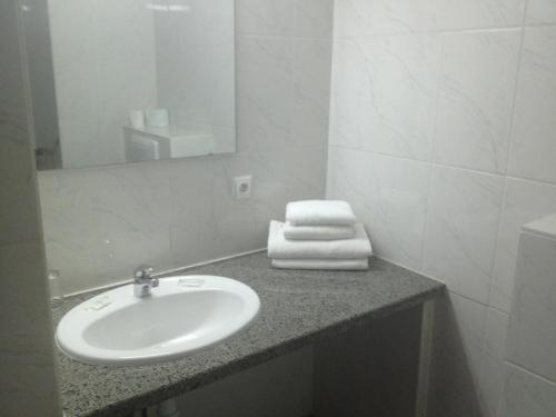 a bathroom with a sink and a mirror at Hotel Le Strasbourg in Mulhouse