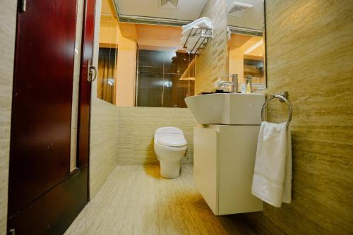 a bathroom with a toilet and a sink and a mirror at Royal Residence Dhaka in Dhaka