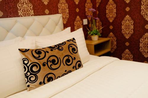a bedroom with a white bed with a pillow at Royal Residence Dhaka in Dhaka