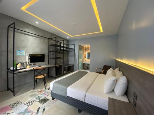 コロンにあるZenvea Hotelのベッドとパソコン付きの机がある寝室