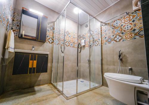 a bathroom with a shower and a toilet and a sink at Lauriston Ooty Town Heritage Bungalow by VOYE HOMES in Ooty