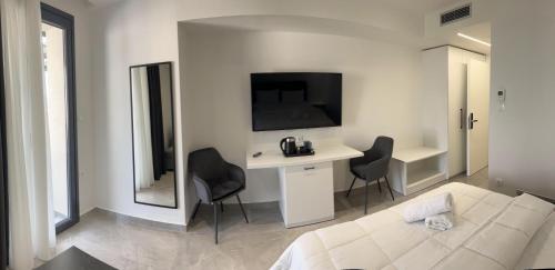 a living room with a couch and a desk and a tv at Eleva Deluxe in Kastoria