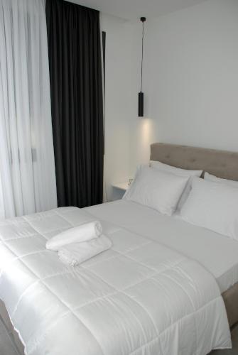 a white bed with two white towels on it at Eleva Deluxe in Kastoria