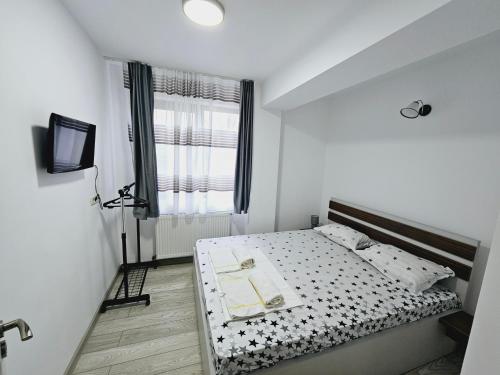 a small bedroom with a bed and a window at Comapart1 in Bacău