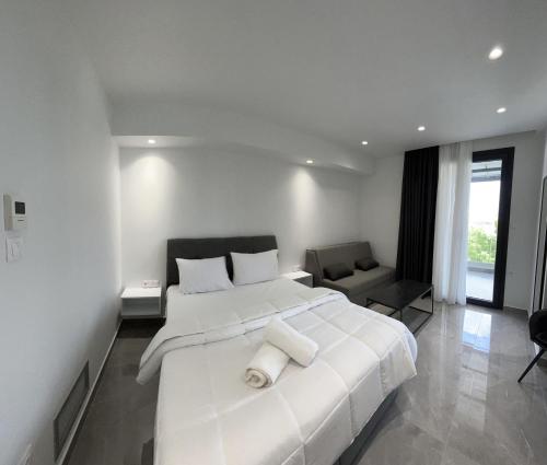 a white bedroom with a large white bed and a chair at Eleva Deluxe in Kastoria