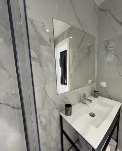 a white bathroom with a sink and a mirror at Eleva Deluxe in Kastoria