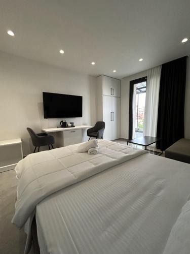 a bedroom with a large white bed and a television at Eleva Deluxe in Kastoria