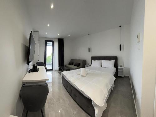 a bedroom with a large white bed and a desk at Eleva Deluxe in Kastoria