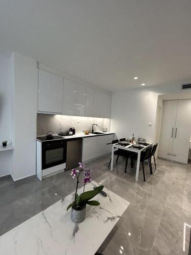 a white kitchen with a table and a dining room at Eleva Deluxe in Kastoria